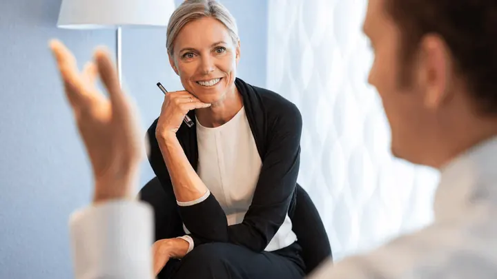 Beratungsgespraech mit Blickkontakt zwischen zwei Personen